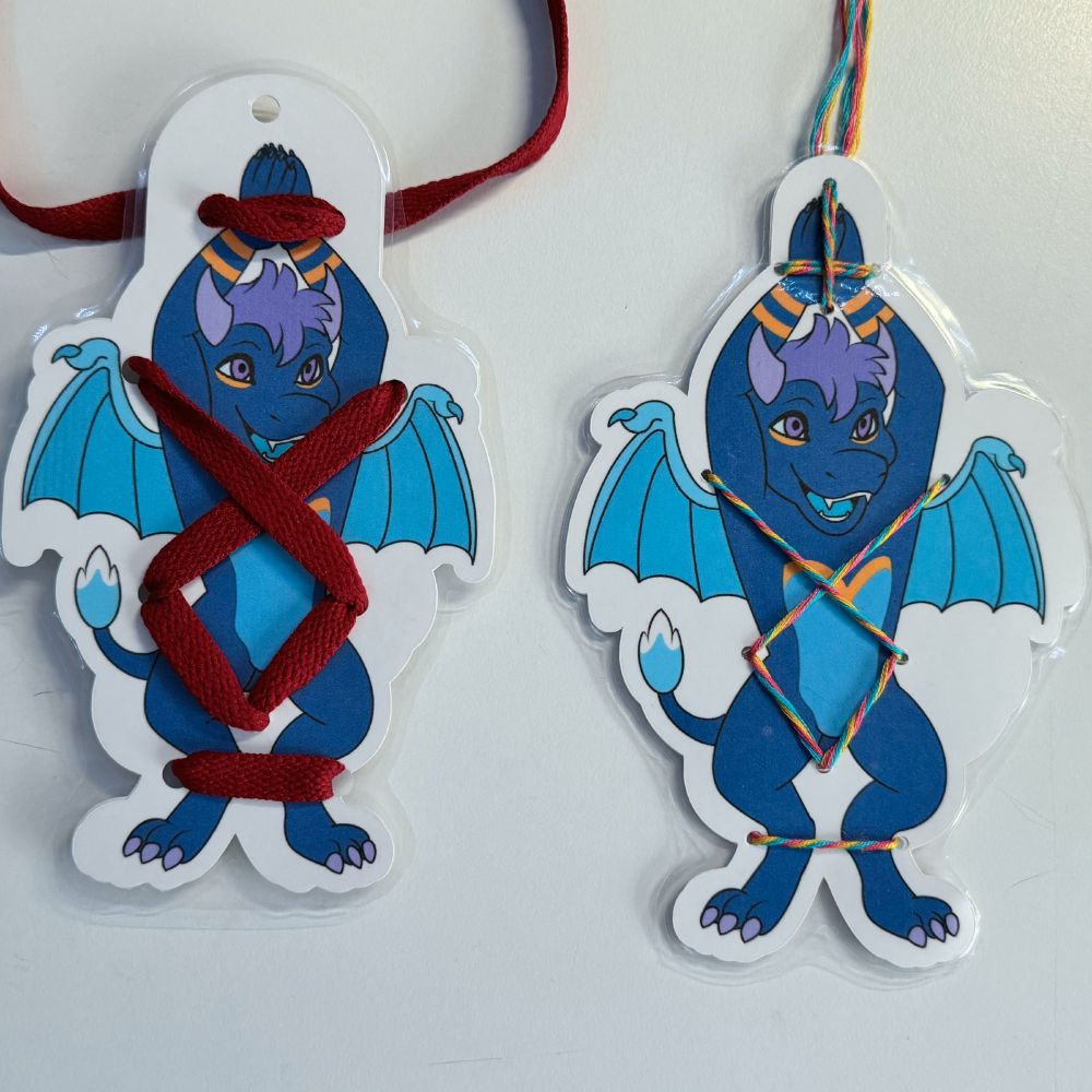 Two blue and gold dragon furry badges, one wrapped in a shoelace, the other in enamel thread