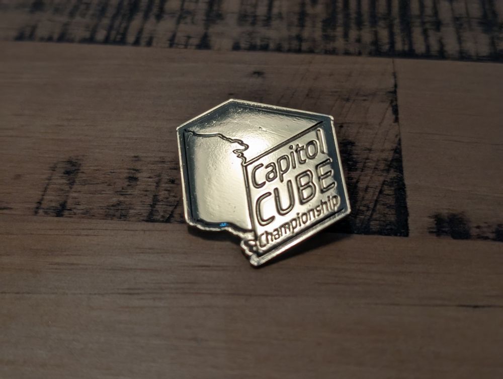 A shiny Capitol Cube Championship trophy pin