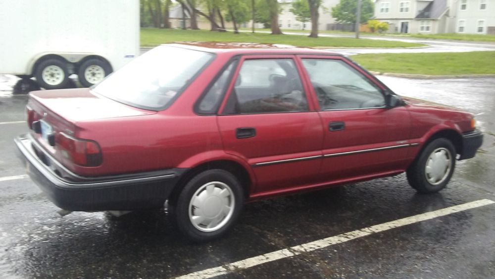 Side view of a red 1991 Geo Prizm