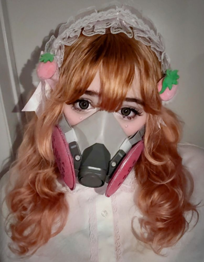 A photo of me wearing a respirator mask and lolita headdress with plush pineberries berries on it. 