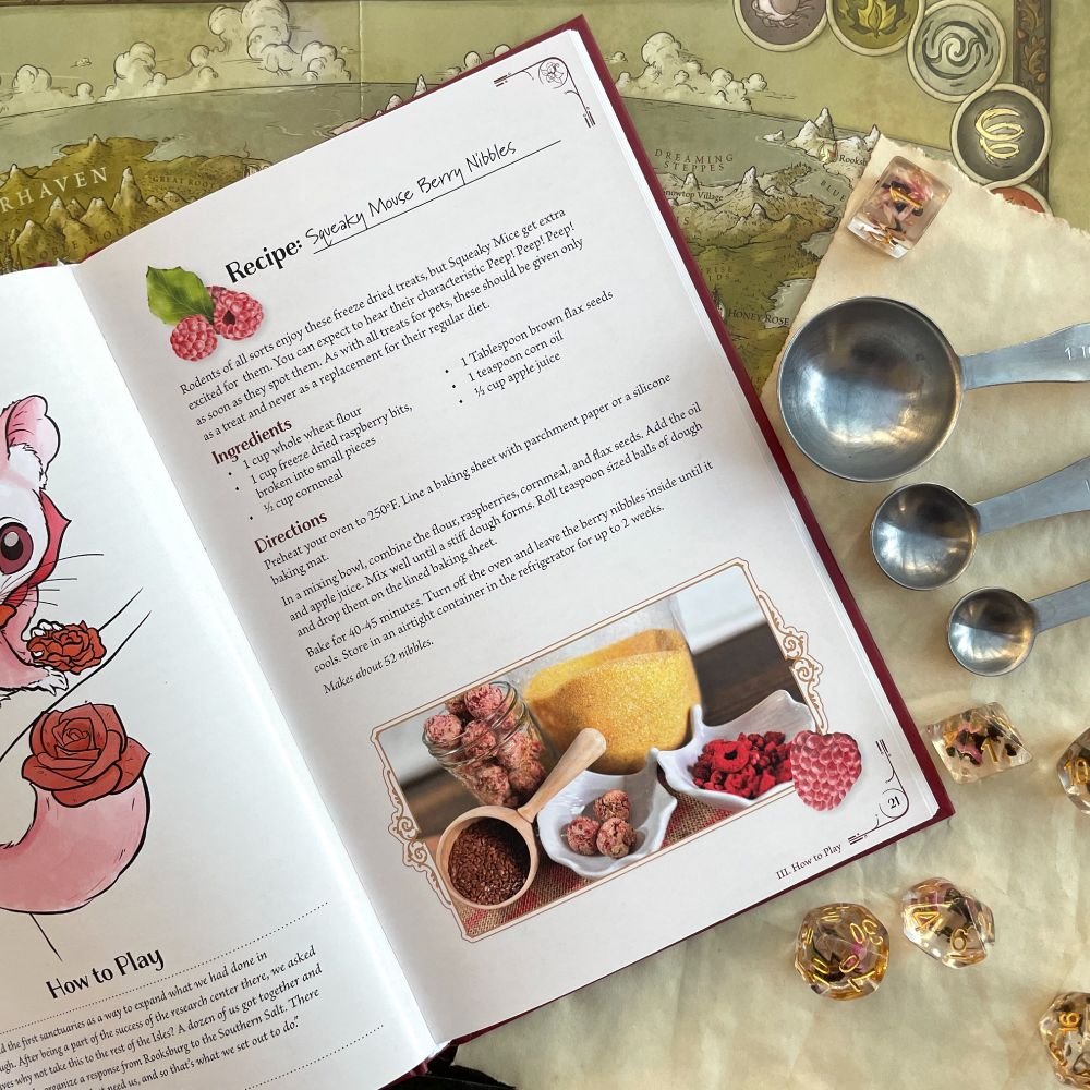 Tea Pets sits open to a recipe page, maps measuring spoons and dice are nearby 