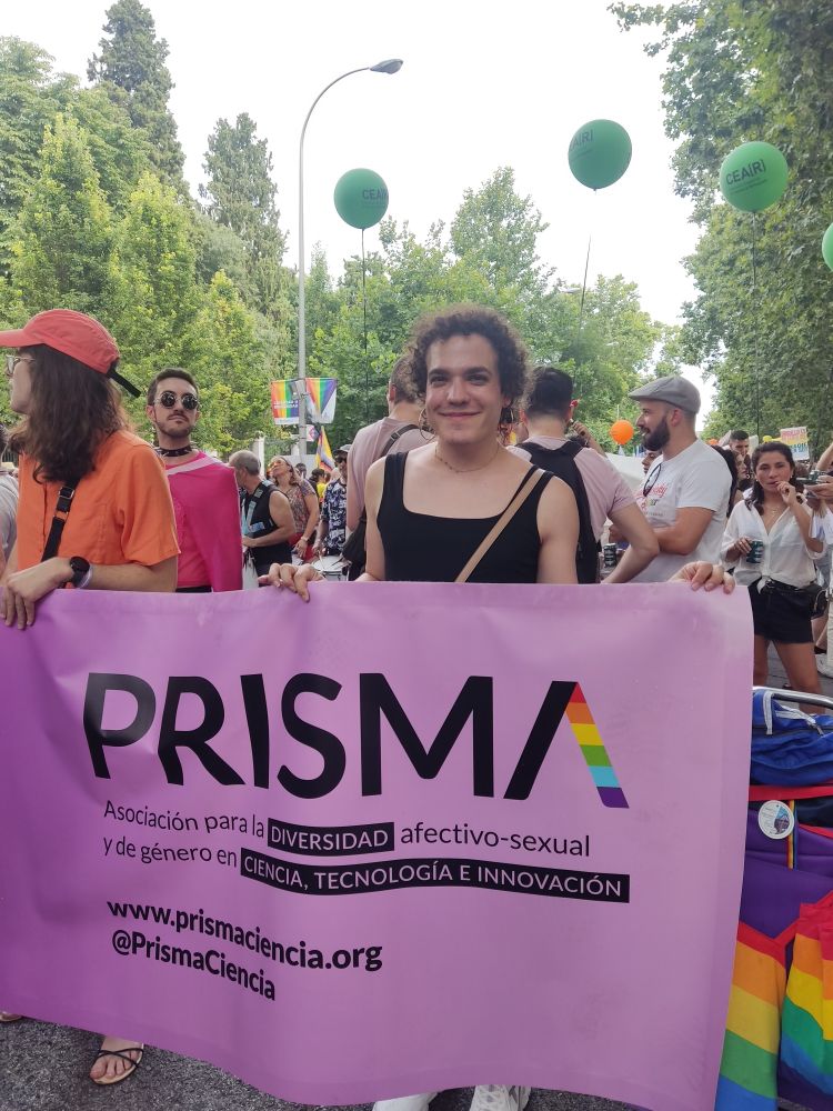 Claudia sujetando la pancarta de la asociación prisma www.prismaciencia.org