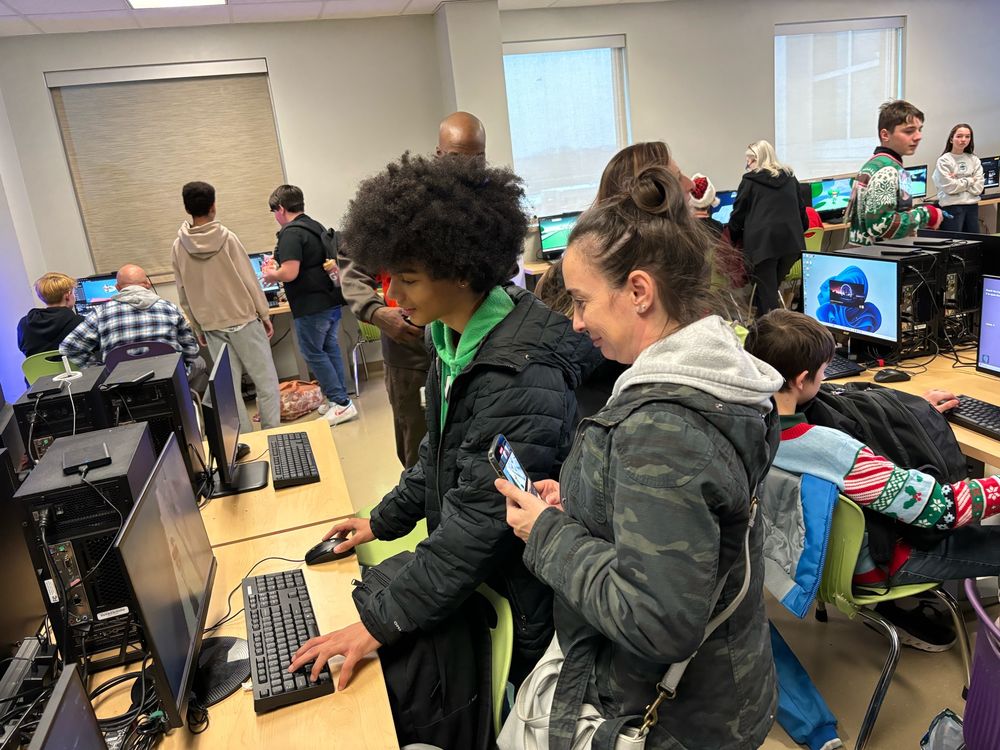 Students and parents looking at videos games students created using unreal engine. 