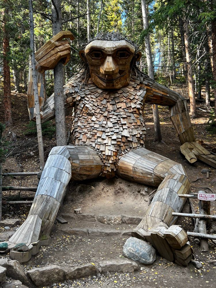 A picture of a large troll made completely out of recycled materials in Breckenridge, CO. He has a mischievous smile 