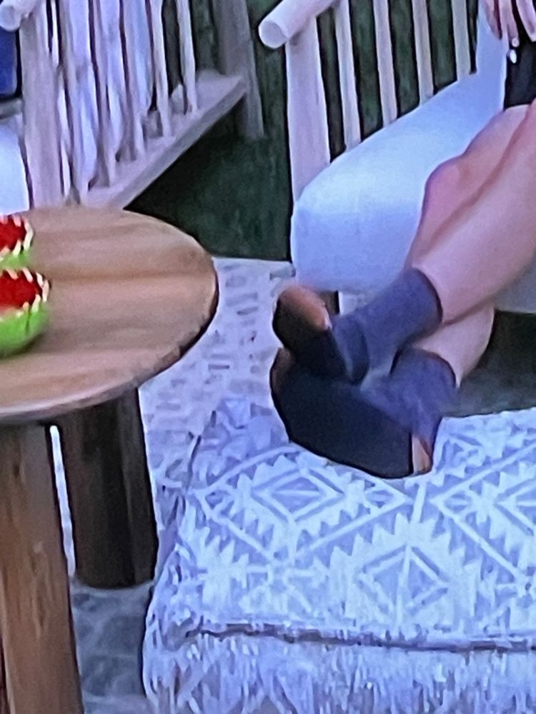 A pair of feet in an ottoman with the toes and heels open.