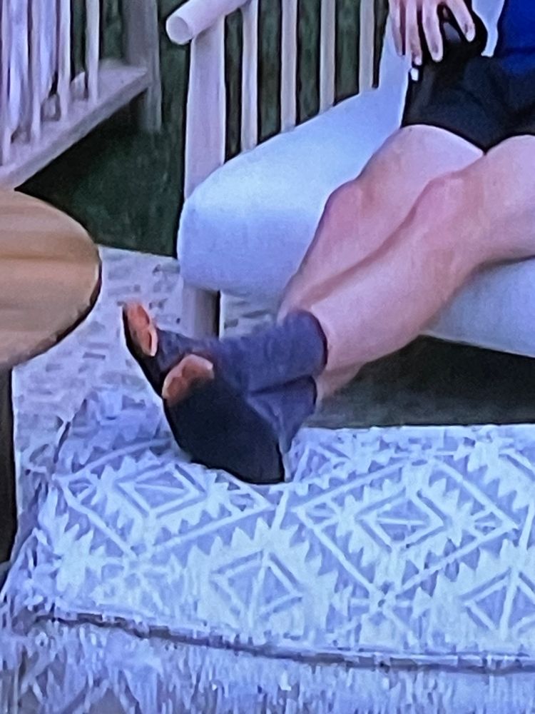 A pair of feet in an ottoman with the toe open.