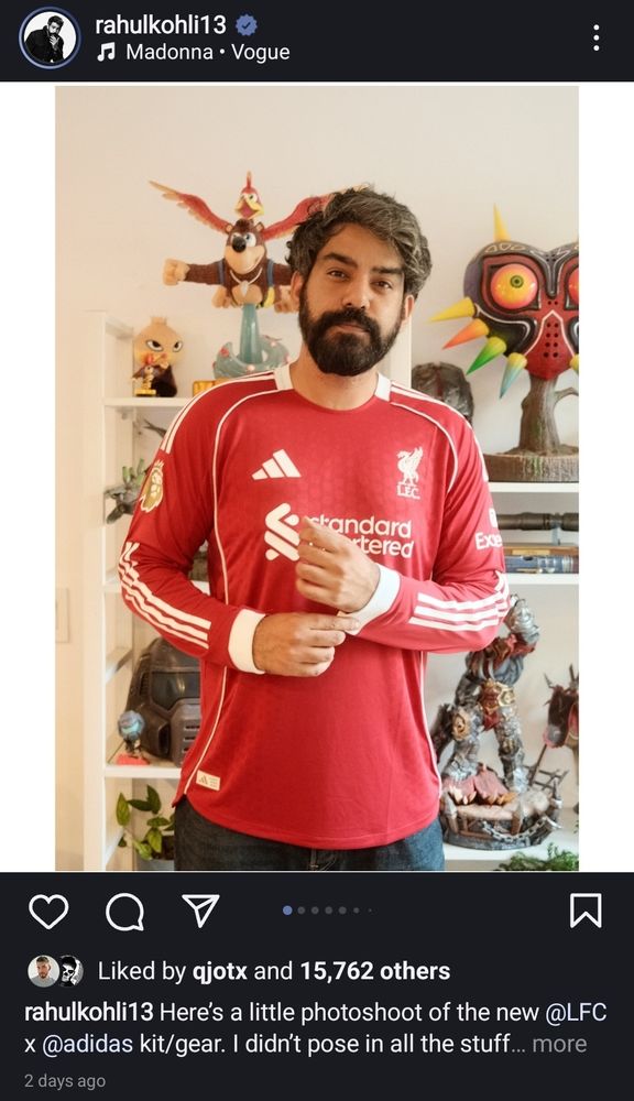 A photo of actor Rahul Kohli from his Instagram page. He is wearing a red football jersey and standing in front of a shelf full of collectibles. 