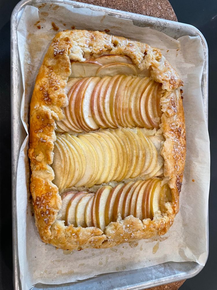 An apple galette on the parchment paper it was baked on.