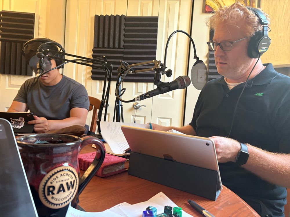 Two people sitting in front of microphones