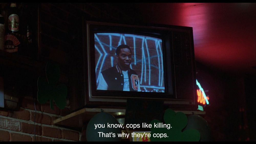 Still from Maniac Cop (1988) a man on tv saying "you know, cops like killing. That's why they're cops."
