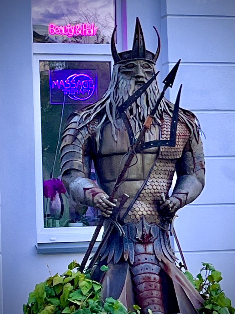 Eine Statue aus Stahl steht vor einem Beautysalon. Sie stellt Poseidon, den Gott des Meeres dar. Swinemünde
