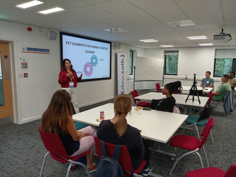 Masha Gaganova talking in front of a slide deck to an audience
