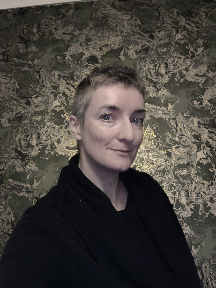 White person with crewcut grey hair wearing black. 