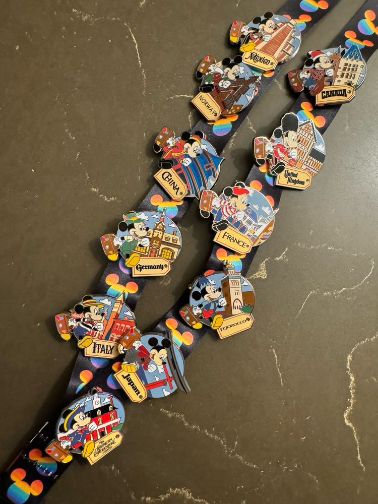 A collection of Disney pins on a lanyard with rainbow Mickey heads
