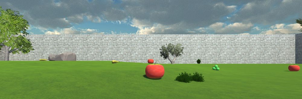 A screenshot from the virtual environment foraging game. The scene shows green grass with a grey stone wall in the background, two trees, a rock, and six pieces of virtual fruit (apples, grapes, and bananas)