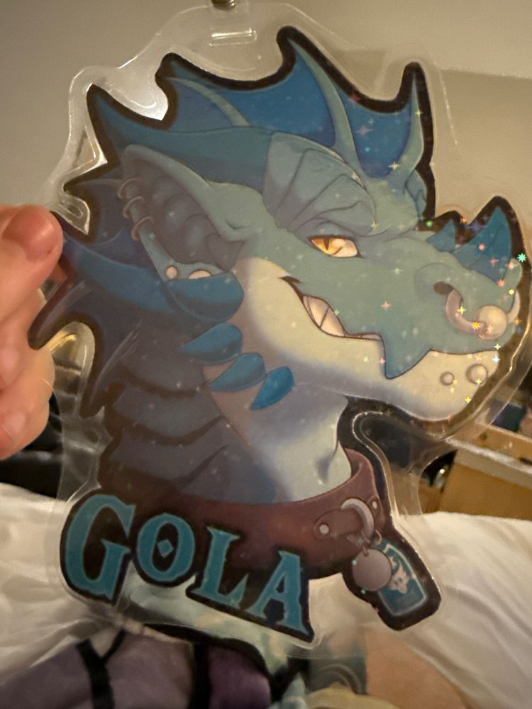 A conventional badge depicting a blue and white kobold head with the writing Gola under it.