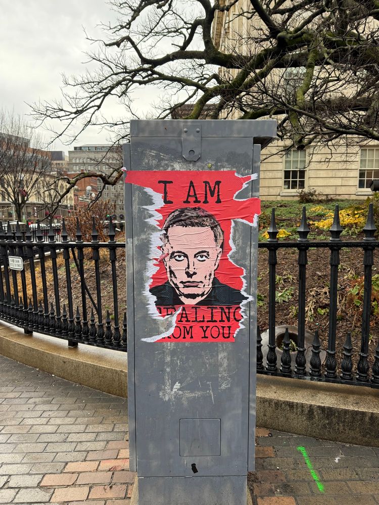 Torn poster of Elon Musk that says I AM STEALING FROM YOU. Taken in DC in February. 