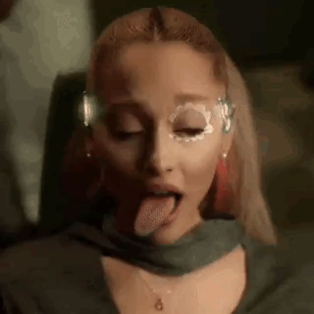 ariana grande is sticking her tongue out in a close up of her face .