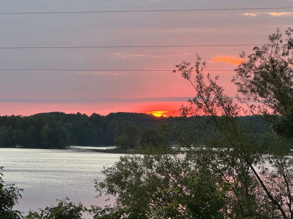 The sunset in the background of a lake. 