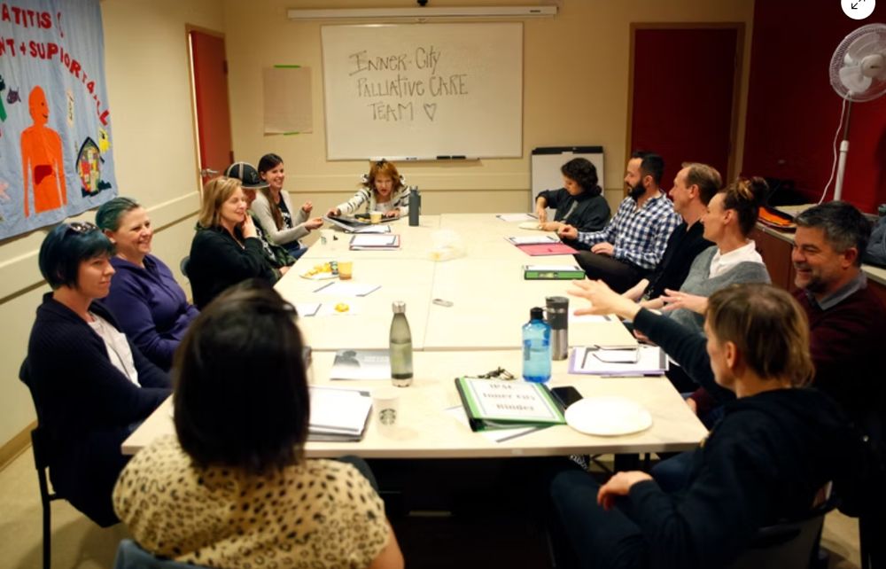 The Inner City Palliative Care Team seated around a rectangular table. 