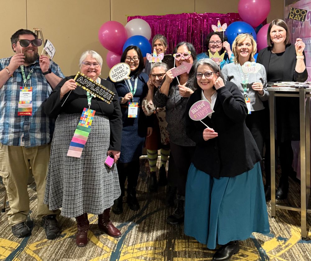 Teacher Librarians from British Columbia in a group photo. They are holding funny signs and props