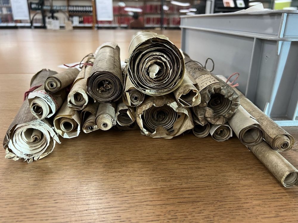 Image of various scrolls on a table in an archive