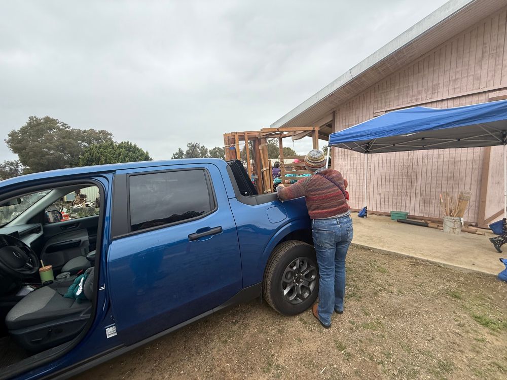 A Blue  truck loaded with a big weaving loom