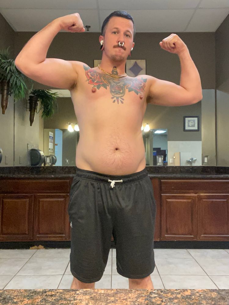 Joey flexes both arms in the mirror 