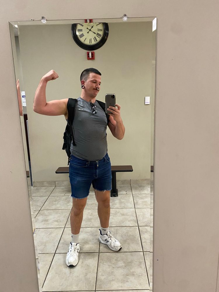 Mirror selfie of Joey at the gym and flexing his bicep 