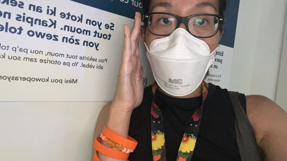 Me freaking out in the hospital lobby I have a bunch of orange bracelets on but also my cat lanyard and an N95 