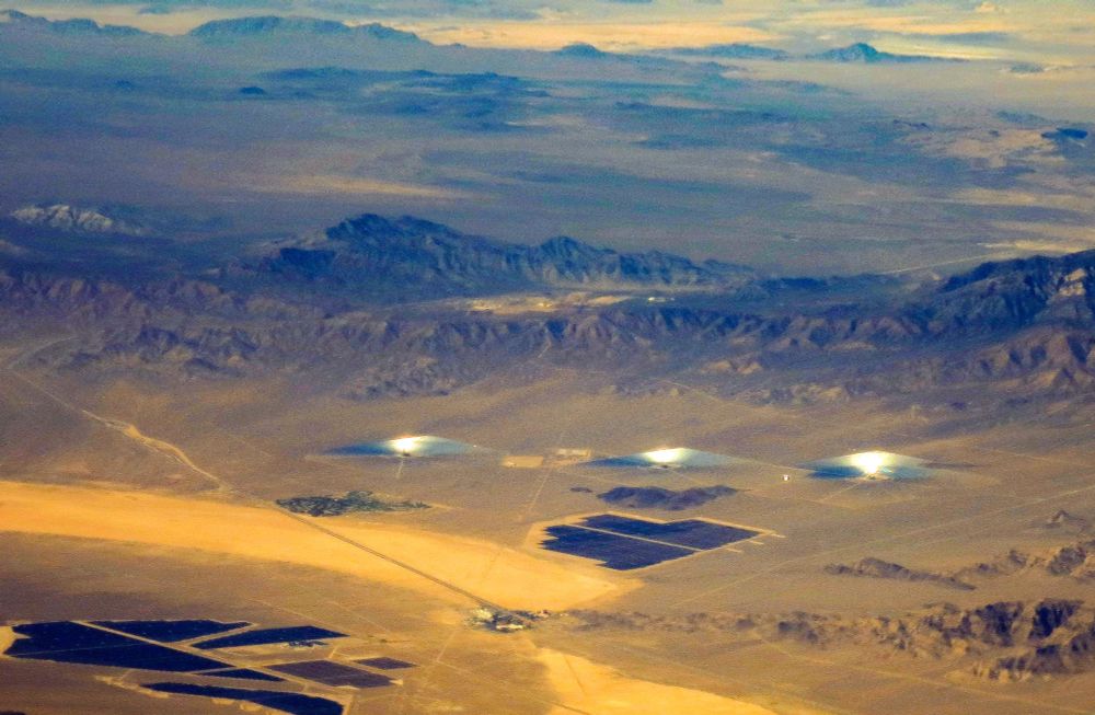 Solar reflector farm in mountainous desert as seen from a passenger jet. 