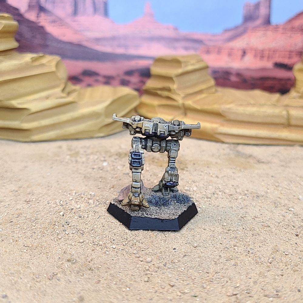 A Battletech Firefly miniature painted tan, green, brown, and blue. Back