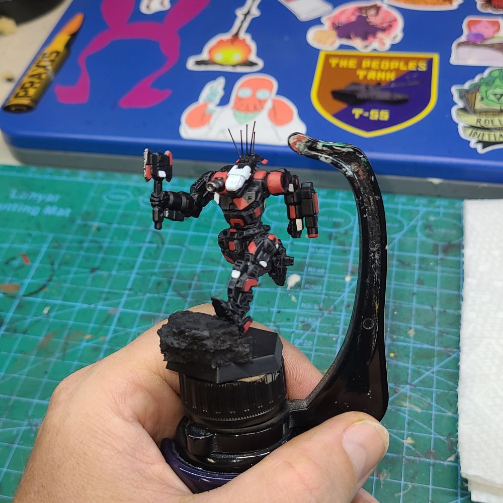 A Battletech Axman miniature painted black, red, and white