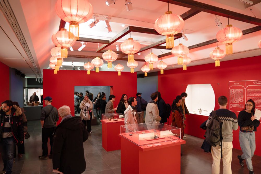 Photo d'ensemble d'une salle de l'exposition du musée Guimet d'une couleur majoritairement rouge.