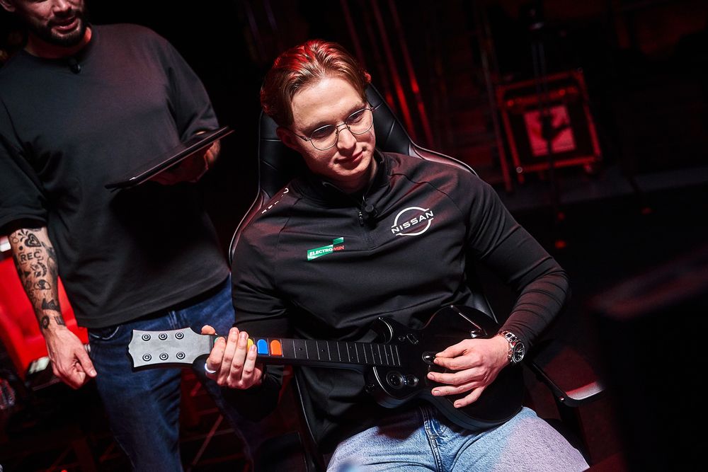 Le champion olympique de Gran Turismo 7, Kylian Drumont, jouant à Gran Turismo 7 à la ... guitare Guitar Hero.