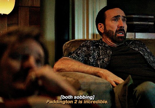 A gif of Nicolas Cage wiping away tears, saying “Paddington 2 is incredible” alongside Pedro Pascal in “The Unbearable Weight of Massive Talent”