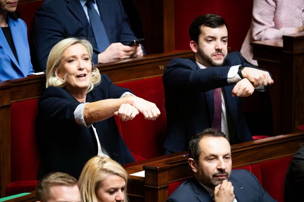 Marine le Pen et Tanguy tendent leurs bras. 