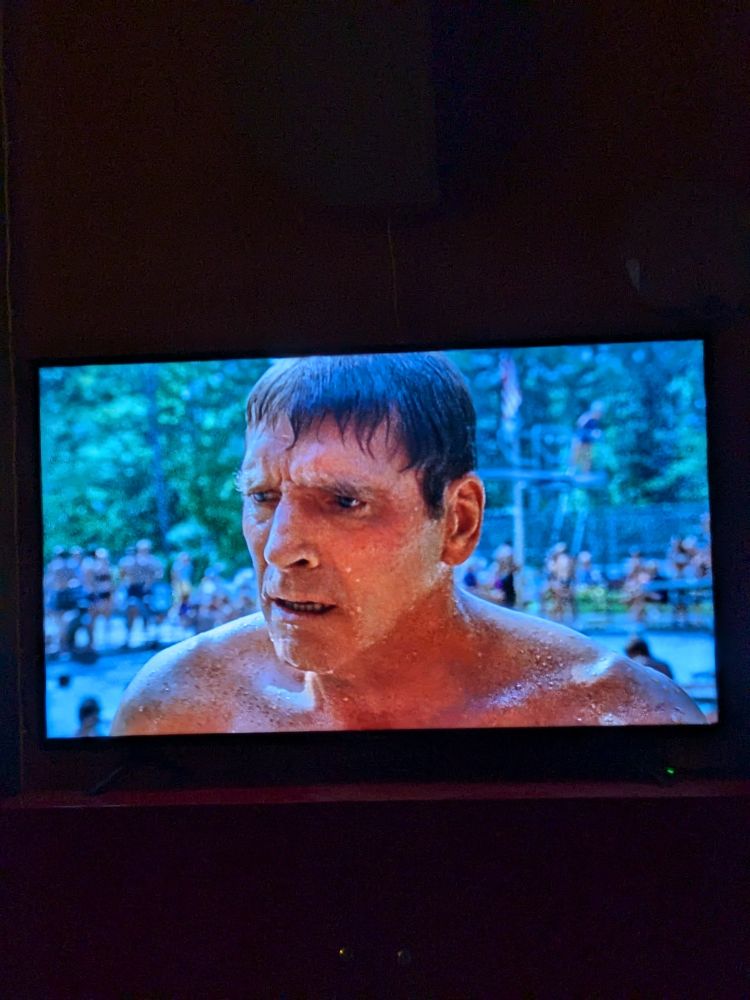 Burt Lancaster as Ned, realizing that his grasp on reality is tenuous, set against a public pool in The Swimmer 