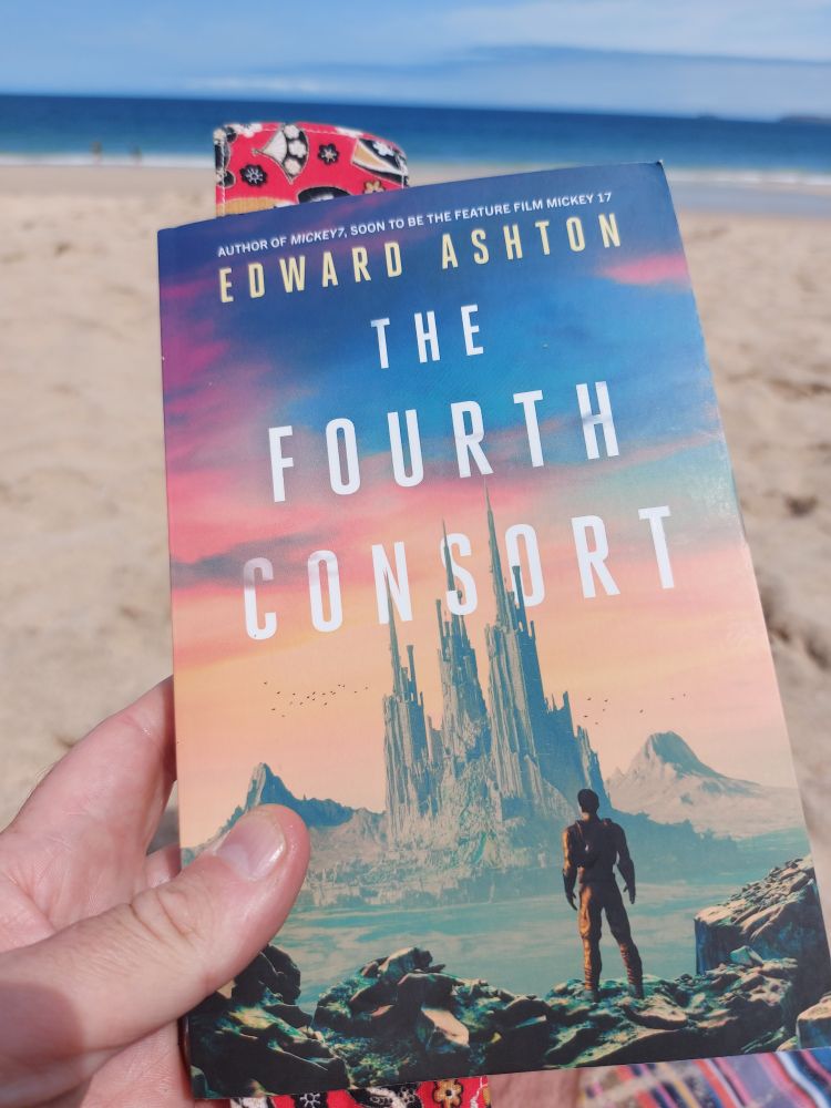 The cover of The Fourth Consort, by  Edward Ashton, showing a space suited figure staring at an alien city in the distance.