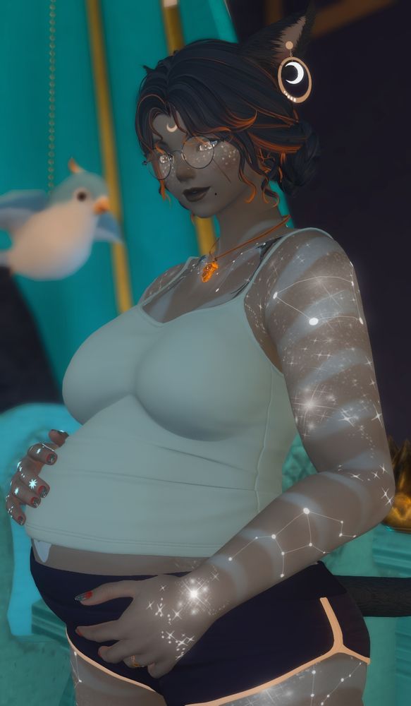 Lura holding her pregnant belly and smiling.