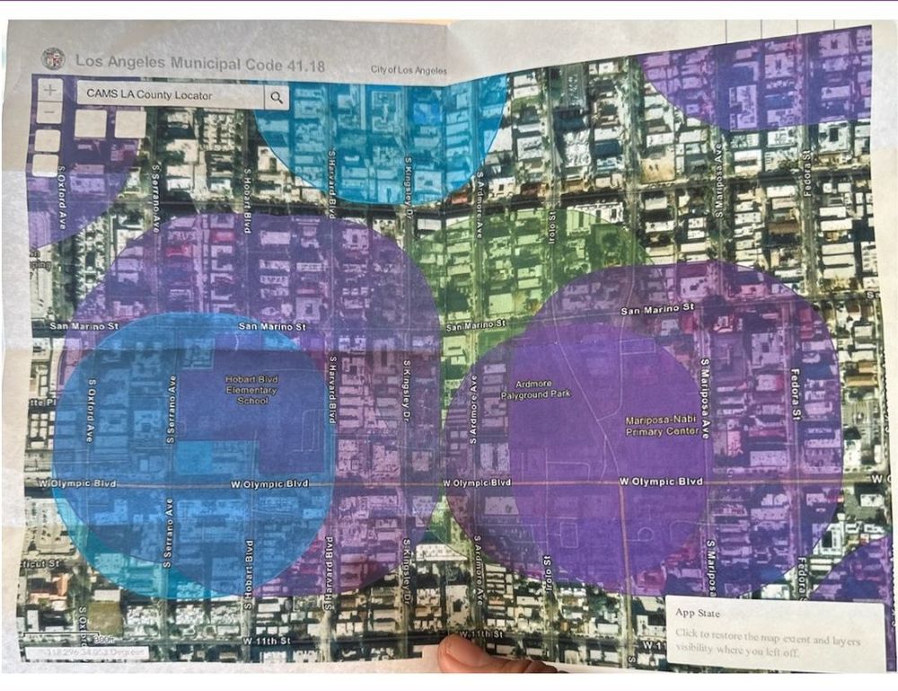 A photograph of a paper map almost entirely covered in green, blue, and purple circles. Only 15-20% is uncovered.