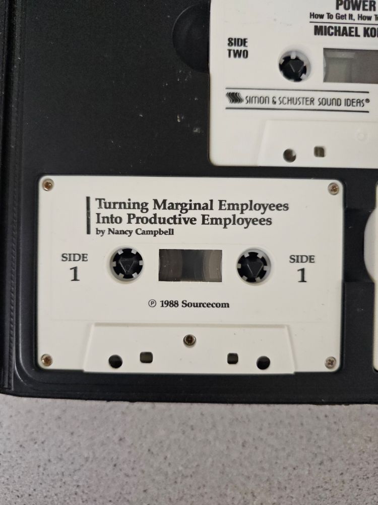 An image of two white cassette tapes. One says, "Power. How to get it". The other says, "Turning Marginal Employees Into Productive Employees".