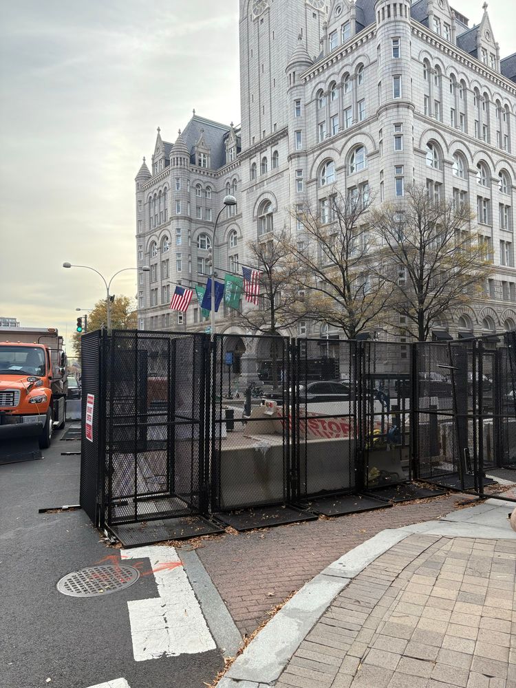 A hotel in DC flying US and Saudi flags, surrounded by barricades and dump trucks. 