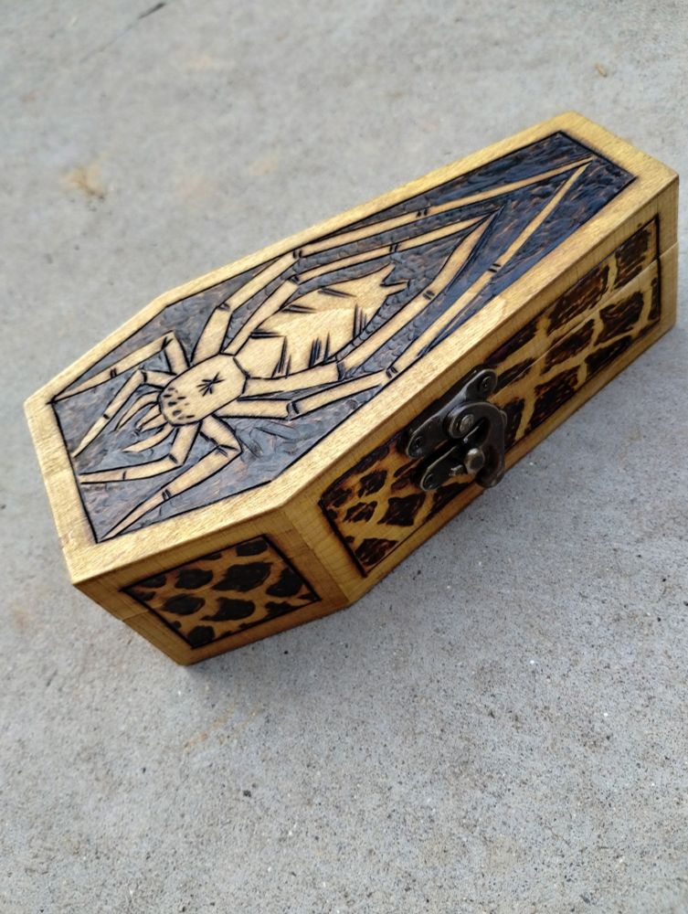 A pyrographed box with a spider on it 