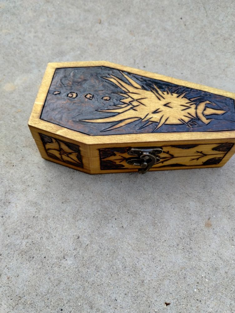 A pyrographed box with a datura pod on it.