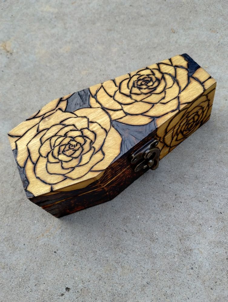 A pyrographed box with roses on it.