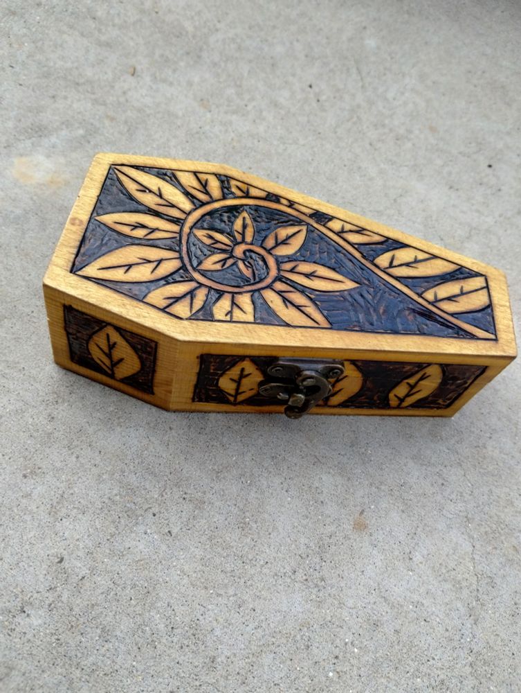 A pyrographed box with a curling fern on it 