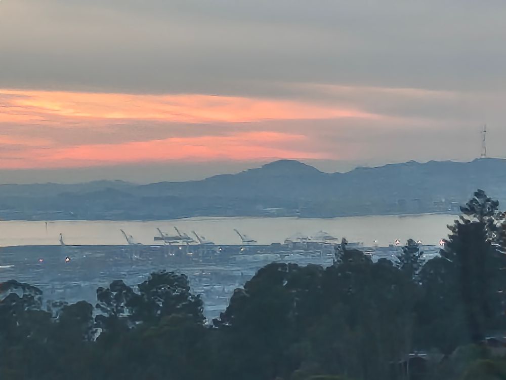 View over the Oakland Bay at sunset with peach and orange colored hues