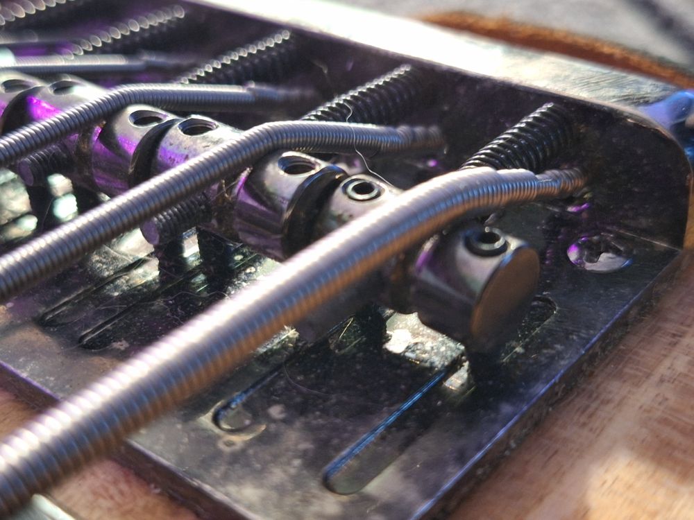 After finally getting the string through bridge it just fit within the saddle. 