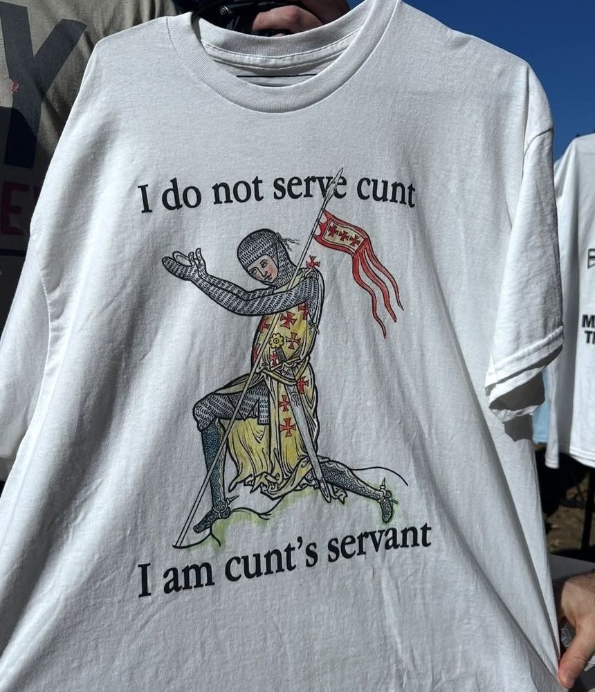 A white shirt with a kneeling knight which says "I do not serve cunt, I am cunt's servant"